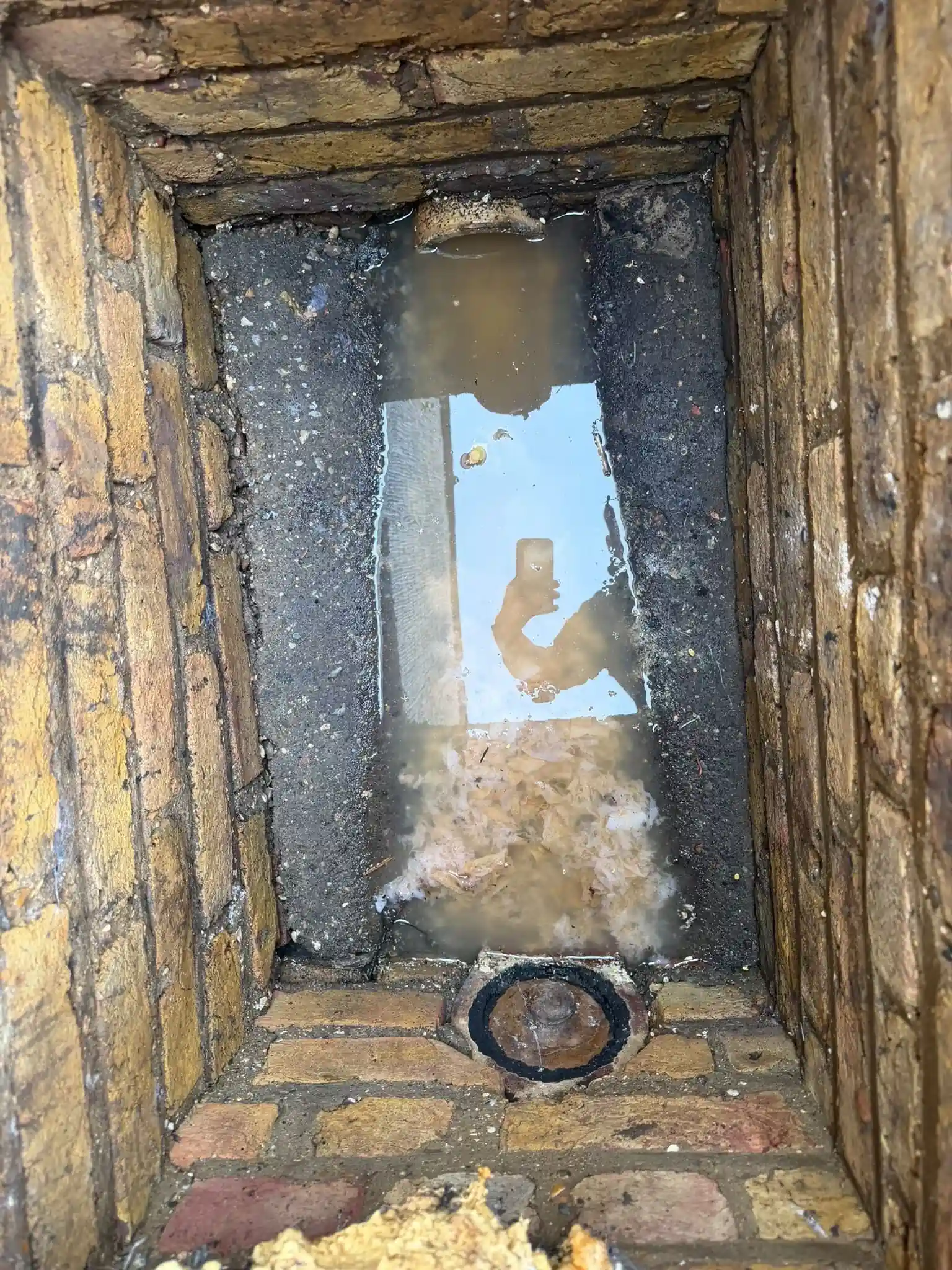 Brick drainage chamber flooded with fat and debris before the defective interceptor trap was replaced